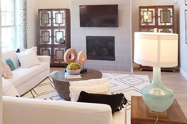 nicely staged living room with a white sectional and a fireplace