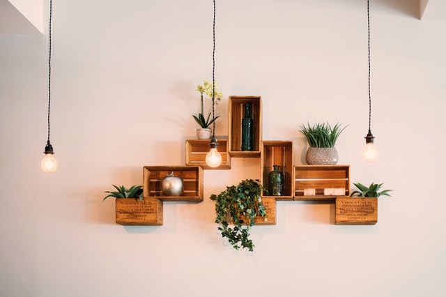 three lightbulbs hanging from the ceiling in front of floating shelves made from wood