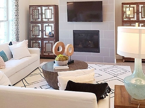 nicely staged living room with a white sectional and a fireplace